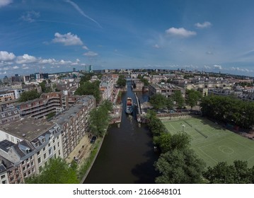 Aerial Drone Panoramic View Of A Ship Passing Elevating Road Bridge In Amsterdam Canal. Ship Under Open Bridge Over The Canal.