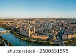 Aerial drone perspective of Spanish city Zaragoza. View of old town center. Cathedral of Zaragoza, Ebro River. Sunset point with orange reflections. Famous travel destination in Aragon - Spain