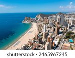 Aerial drone photo of the beautiful town of Benidorm in Spain showing the south beach Promenade golden sandy beach and apartments on a sunny summers day with a blue sky and a few clouds