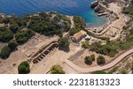 Aerial drone photo of famous archaeological site of Heraion in Cape Melagavi featuring a small beach next to iconic lake Vouliagmeni and lighthouse, Corinthian bay, Perachora, Loutraki, Greece