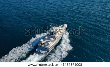 Aerial drone photo of Hellenic Coastguard powerboat cruising in high speed in deep blue Aegean sea