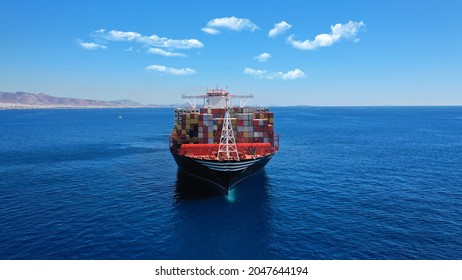 Aerial Drone Photo Of Huge Container Tanker Ship Carrying Truck Size Colourful Containers In Deep Blue Open Ocean Sea