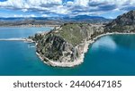 Aerial drone photo of iconic Acronafplia fortress overlooking old city of Nafplio below famous castle of Palamidi as seen in a spring morning with beautiful clouds and deep blue sky, Argolida, Greece