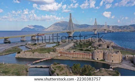 Aerial drone photo of iconic medieval ancient castle of Rio built next to modern cable strait bridge of Harilaos Trikoupis crossing corinthian Gulf, Central Greece