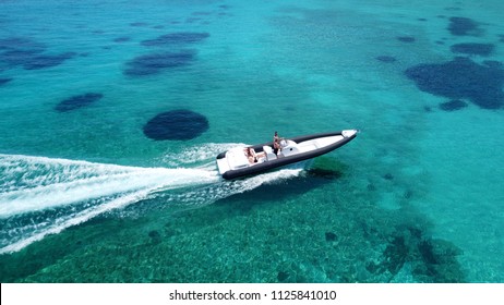 Aerial drone photo of inflatable power boat cruising in high speed in tropical emerald clear water sea