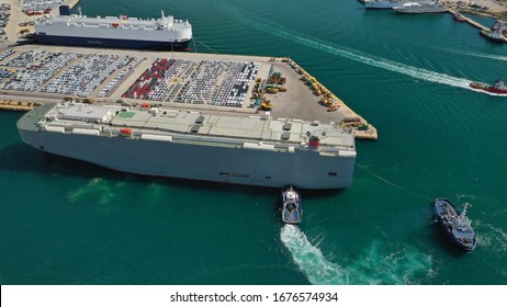 Aerial Drone Photo Of Large Car Carrier Ro Ro Vessel Guided By Tug Boats To Dock To Mediterranean Port