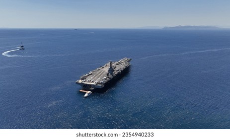 Aerial drone photo of latest technology American flag nuclear aircraft carrier anchored in deep blue sea