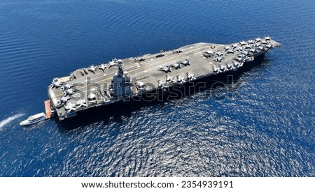 Aerial drone photo of latest technology nuclear powered aircraft carrier anchored in deep blue open ocean sea