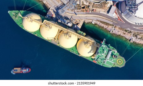 Aerial drone photo of LNG (Liquified Natural Gas) tanker anchored in small gas terminal island with tanks for storage