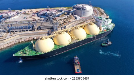 Aerial drone photo of LNG (Liquified Natural Gas) tanker anchored in small LNG industrial islet of Revithoussa equipped with tanks for storage, Salamina, Greece