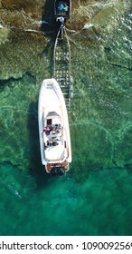 Aerial Drone Photo Of Luxury Speed Boat Being Taken Out Of Water By Trailer In Tropical Rocky Beach With Crystal Clear Waters