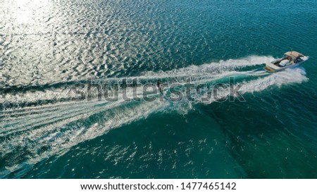 Aerial drone photo of man practicing high speed water ski towed by speed boat in Mediterranean popular destination with emerald clear sea