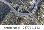 Aerial drone photo of modern Attiki Odos toll multilevel interchange highway with Kaisariani and mount Hymetus, Athens, Attica, Greece