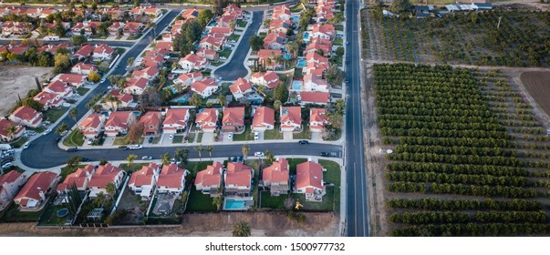 Aerial Drone Photo Of A Neighborhood Next To A Citrus Grove In Southern California Near Sunset