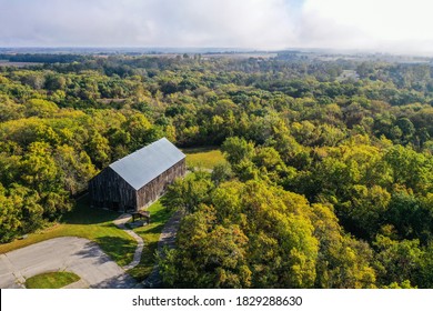 Aerial drone photo of an old, historic, tobacco barn in the public Weston Bend State Park in Missouri north of Kansas City. Trees are just getting their fall colors.
