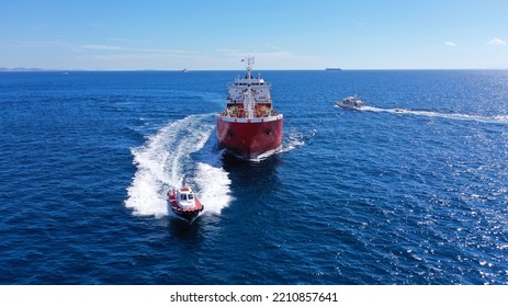 Aerial drone photo of pilot boat and huge crude oil tanker cruising in open ocean deep blue sea - Powered by Shutterstock