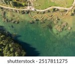 Aerial drone photo of Quarry turquiose lake colour, open pit mining in Park Grodek, Jaworzno. Poland. Turquiose Water and Wooden Bridge. Polish Maldives Park Grodek in Jaworzno from drone.