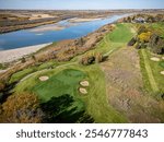 An aerial drone photo of Riverside Golf Course in Saskatoon, Saskatchewan, showcasing the manicured greens, fairways, tree-lined holes, and views of the South Saskatchewan River in a scenic setting.