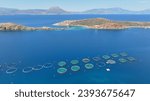 Aerial drone photo of sea bass small fish farming unit or fishery operating in small Mediterranean bay with calm sea using cages to breed fish
