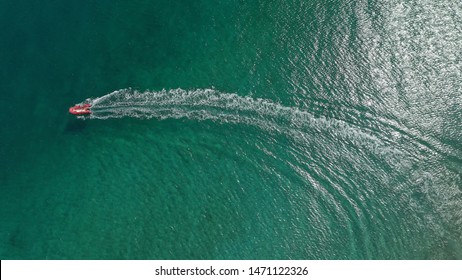 Aerial drone photo of small inflatable boat in tropical exotic bay with turquoise open ocean sea