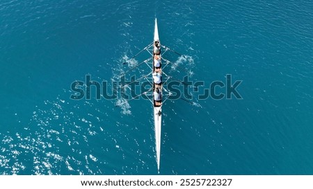 Aerial drone photo of sport canoe operated by team of young trained athletes in deep emerald sea