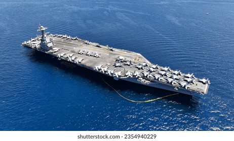 Aerial drone photo of USS Gerald R. Ford latest technology nuclear powered aircraft carrier anchored in deep blue open ocean sea