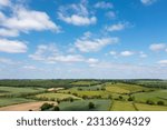 Aerial drone photo of the village of Great Houghton in the Metropolitan Borough of Barnsley in South Yorkshire, England showing wind turbines and farmers fields in the summer time.