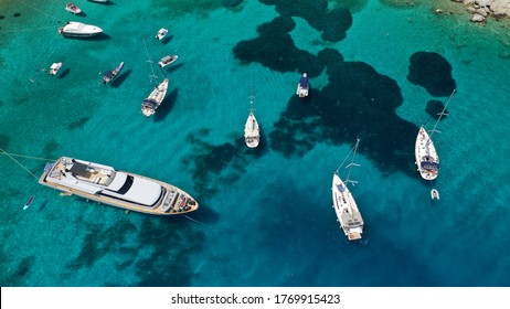 Aerial drone photo of yacht anchored in popular bay and beach of Super Paradise, Mykonos island, Cyclades, Greece