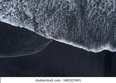 Aerial drone shoot from above black sand beach. Nature texture