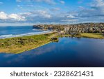 Aerial drone shot of a beach and lagoon lake during golden hour in Sydney Australia