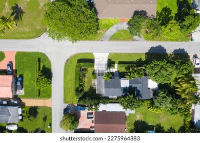 Aerial drone shot of an elegant and modern area in the West Flagler neighborhood, in Little Havana, modern houses, short grass, suburbs, trees and palm trees, streets, and parked cars