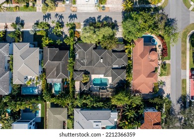 Aerial Drone Shot Of An Elegant Neighborhood Of Mansions And Luxury Houses With Tropical Vegetation, Swimming Pools, Tiled Roofs