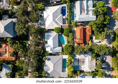 Aerial Drone Shot Of An Elegant Neighborhood Of Mansions And Luxury Houses With Tropical Vegetation, Swimming Pools, Tiled Roofs