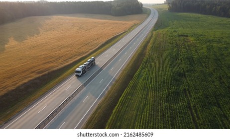 Aerial drone shot: Large car transporter (car hauler) delivery truck is fully loaded on the highway. Transportation of new cars from the factory to the car dealership.	

