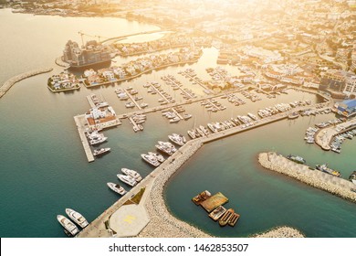 Aerial drone shot of Limassol Marina, Cyprus, at sunset. Yachts and boats docket. Modern luxury villas and construction of a new estate.