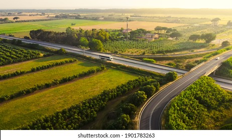 Aerial Drone Shot: Long Haul Semi Truck Driving On The Busy Highway In The Rural Region Of Italy. Beautiful Scenery Of Nature And Human Logistics Progress