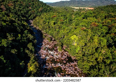 Aerial Drone Shot Of Taken At Mossman Gorge In The Daintree National Park Featuring Water Flowing Along The Rocks And Dense Rainforest