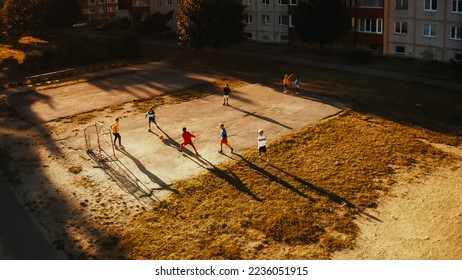 Aerial Drone Taking Off Shot of Neighborhood Friends Playing Soccer Outside in Urban Backyard. Multicultural Kids Play Football Together in the Suburbs. Happy Childhood and Sports Concept. - Powered by Shutterstock