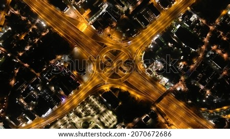 Aerial drone top down night slow shutter shot of urban ring multilevel interchange highway road passing through city centre