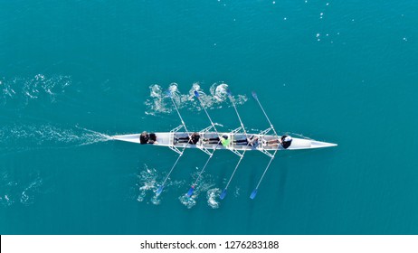 Aerial drone top down photo of sport canoe operated by team of young women in emerald clear waters