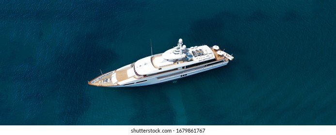 Aerial Drone Top Down Photo Of Luxury Yacht With Wooden Deck Anchored In Open Ocean Sea