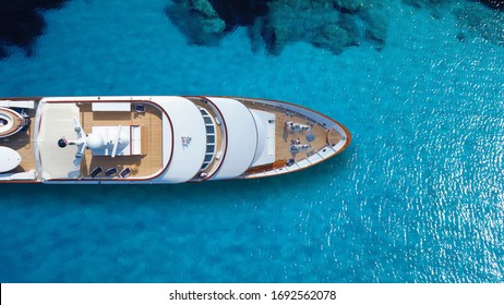 Aerial drone top down photo of luxury exotic yacht nose with wooden deck anchored in paradise turquoise bay - Powered by Shutterstock