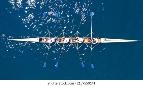 Aerial drone top down photo of sport canoe operated by team of young women in deep blue calm sea waters