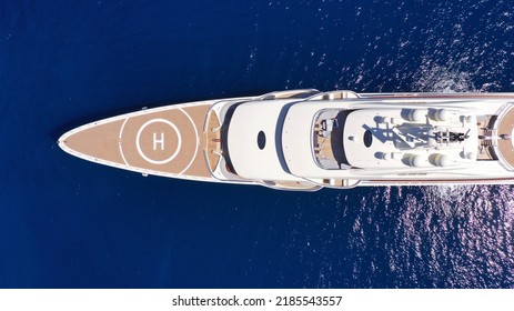 Aerial Drone Top Down Photo Of Luxury Mega Yacht With Wooden Deck And Helipad Anchored In Deep Blue Mediterranean Sea