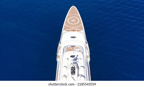 Aerial Drone Top Down Photo Of Luxury Mega Yacht With Wooden Deck And Helipad Anchored In Deep Blue Mediterranean Sea