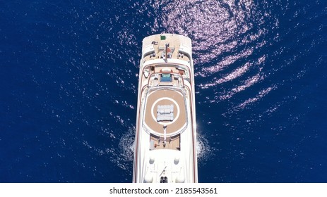 Aerial Drone Top Down Photo Of Luxury Mega Yacht With Wooden Deck And Helipad Anchored In Deep Blue Mediterranean Sea