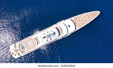 Aerial Drone Top Down Photo Of Luxury Mega Yacht With Wooden Deck And Helipad Anchored In Deep Blue Mediterranean Sea