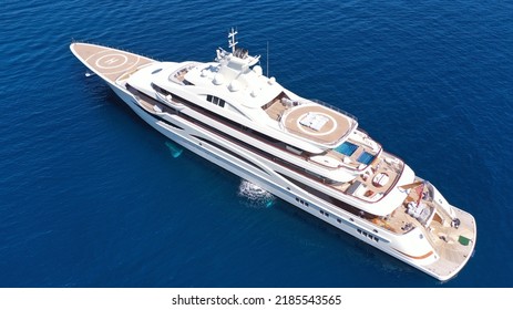 Aerial Drone Top Down Photo Of Luxury Mega Yacht With Wooden Deck And Helipad Anchored In Deep Blue Mediterranean Sea