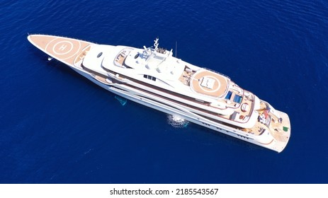 Aerial Drone Top Down Photo Of Luxury Mega Yacht With Wooden Deck And Helipad Anchored In Deep Blue Mediterranean Sea