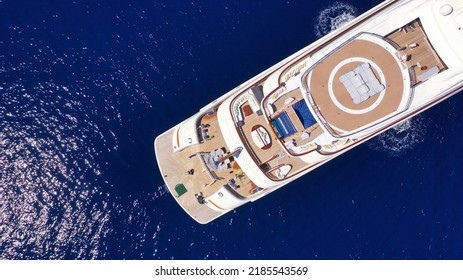 Aerial Drone Top Down Photo Of Luxury Mega Yacht With Wooden Deck And Helipad Anchored In Deep Blue Mediterranean Sea